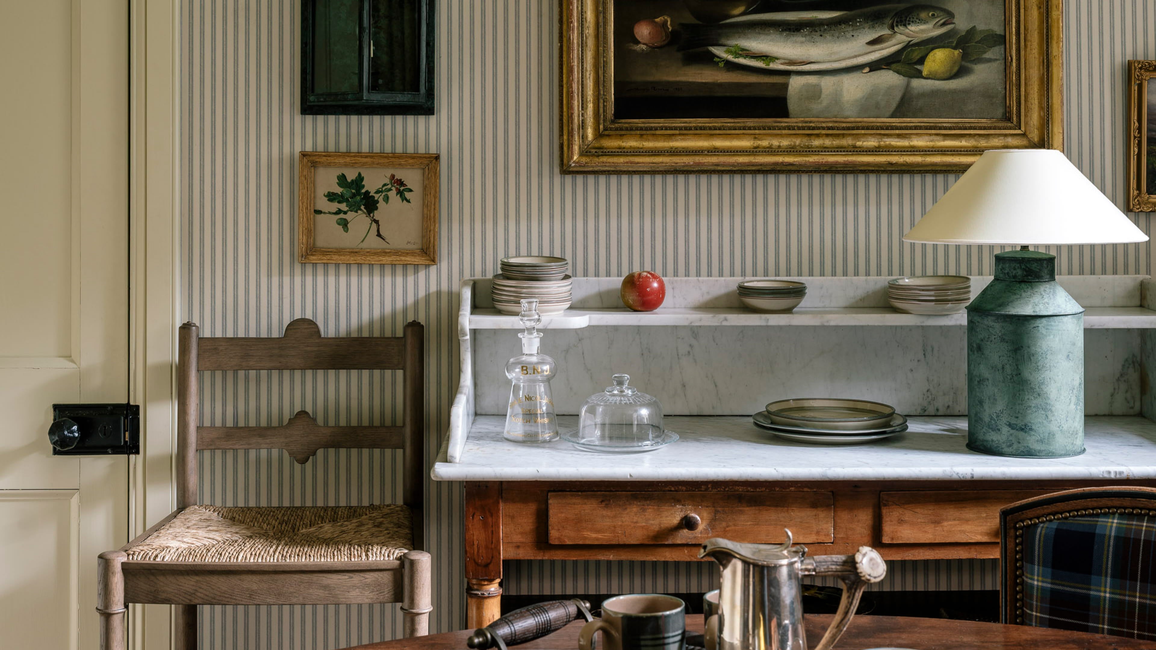 Rustic kitchen with fluted plaster walls, a marble countertop, vintage glassware, and a green patina metal lamp