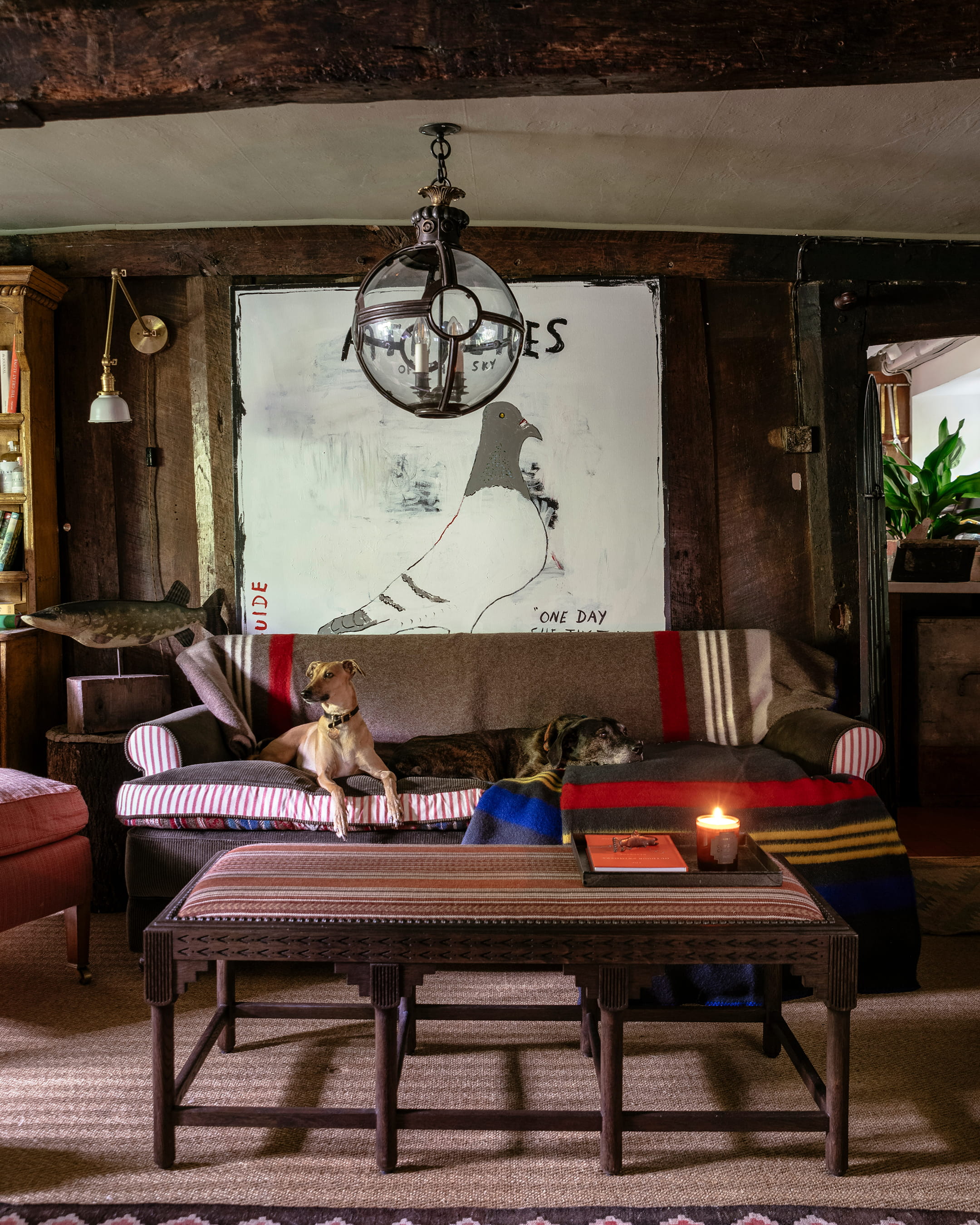 Cozy living room featuring a striped pink and white sofa, a rustic wooden coffee table, and a large bird artwork on the wall