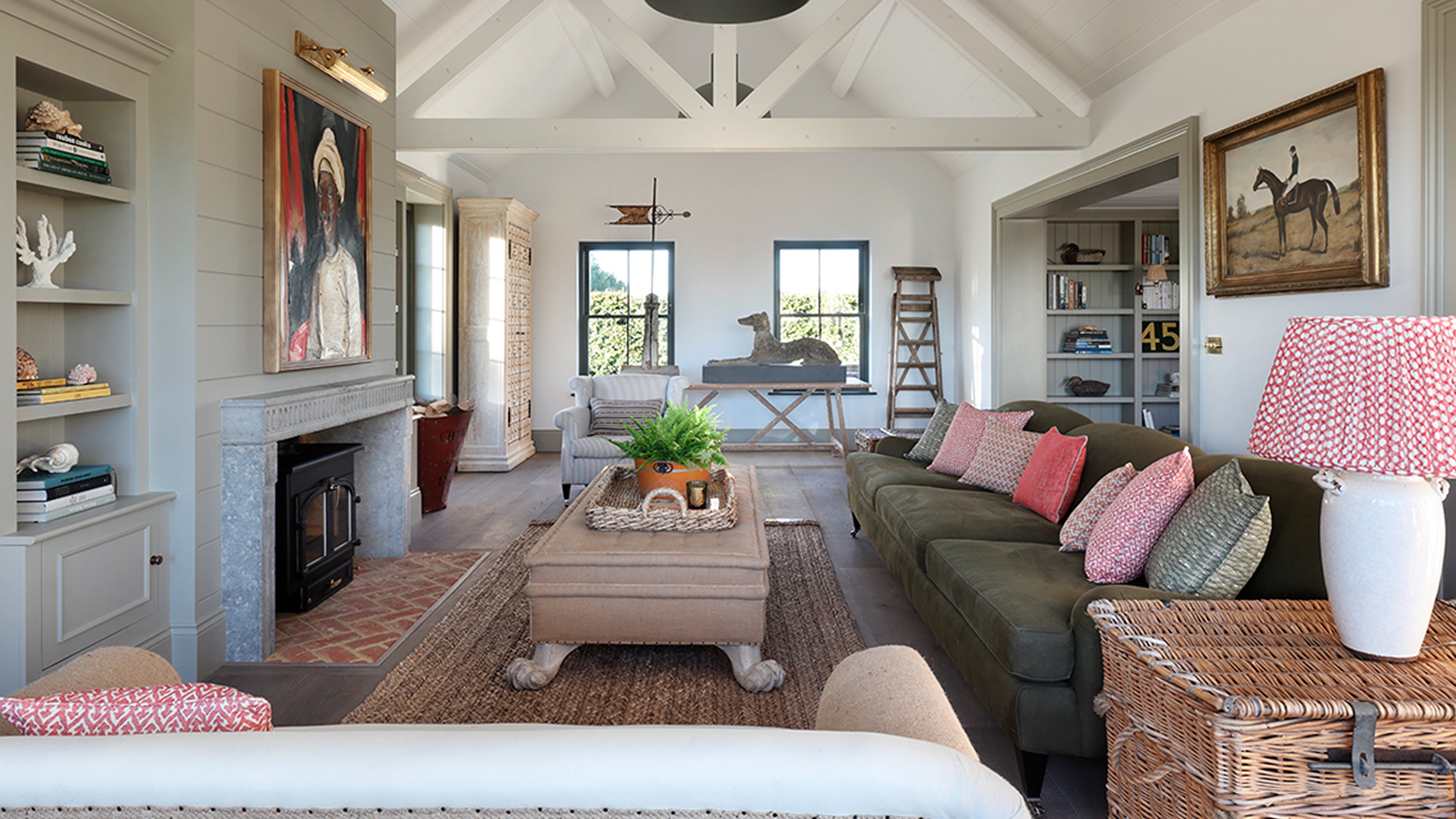 Bright living room featuring light grey shiplap walls, a rustic brick fireplace, and a large woven jute rug under a linen sofa